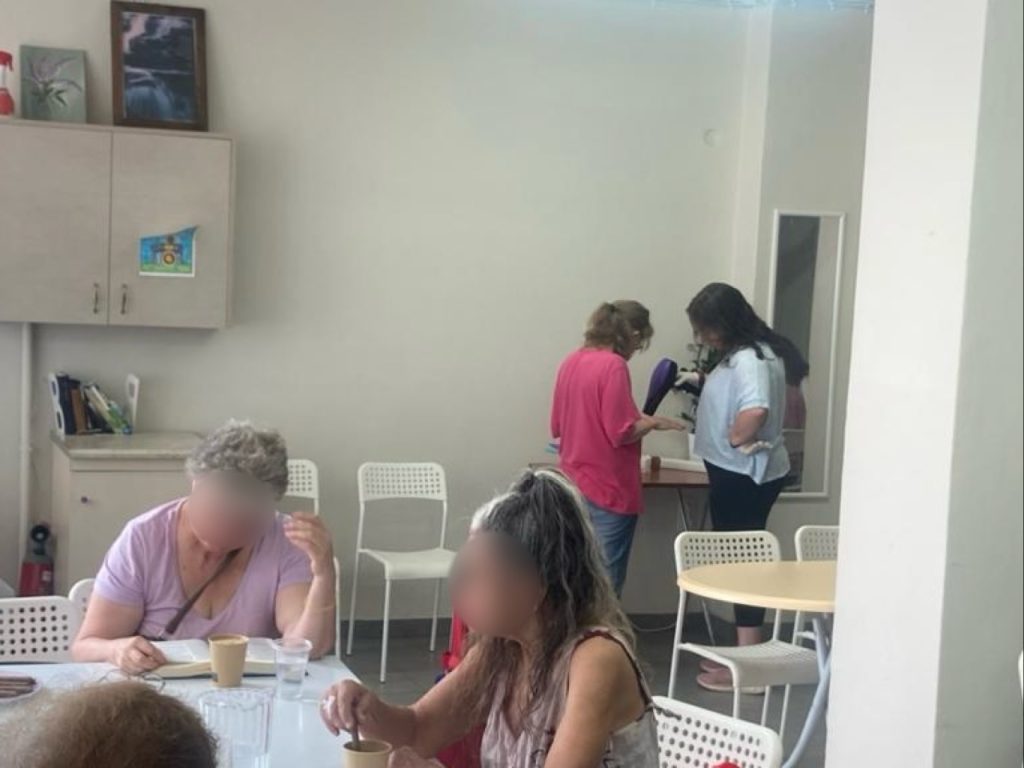 Guests are pampered with hairstyling as part of the shower ministry, while others share coffee and conversation nearby.