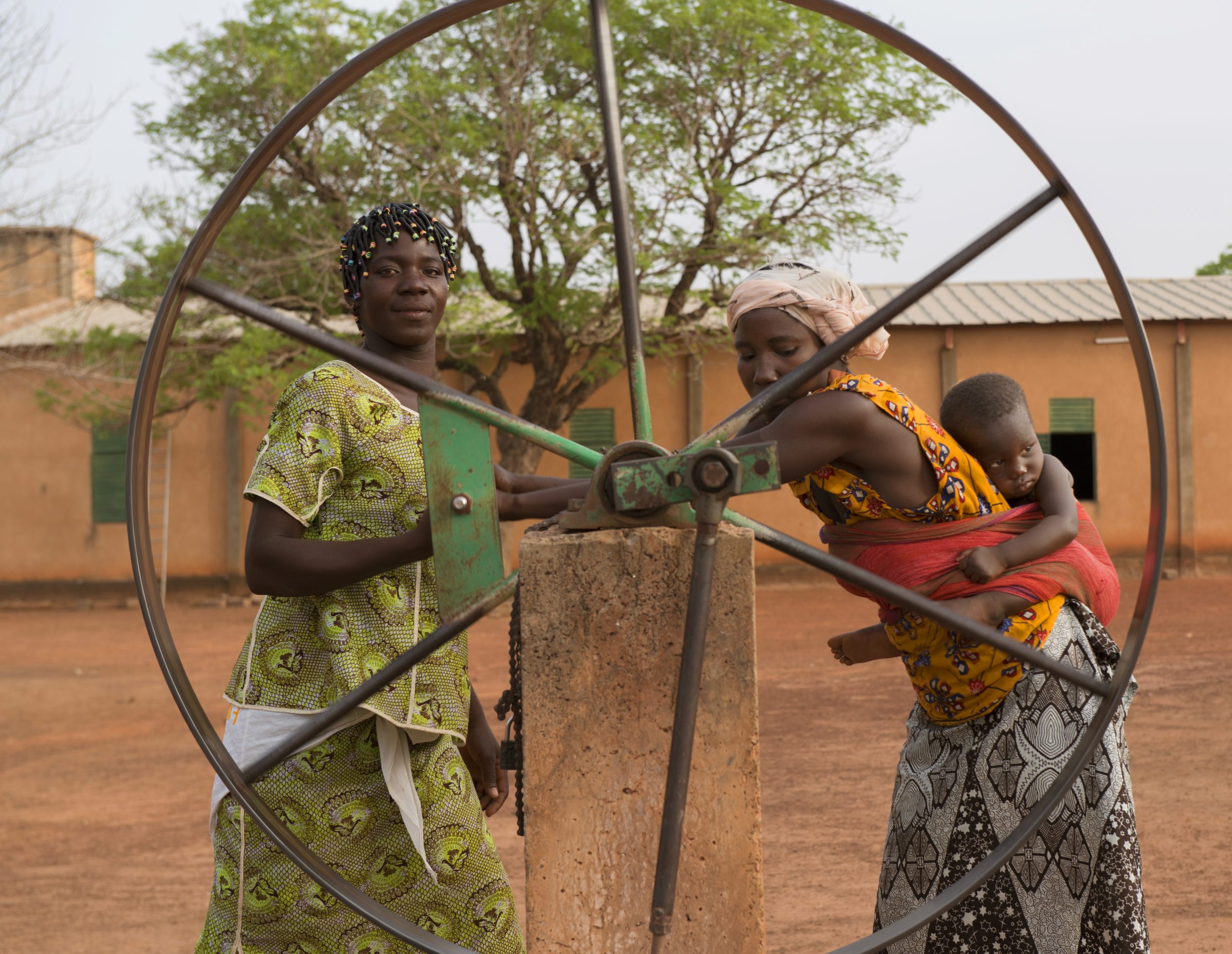 Two women drawing water at a community well